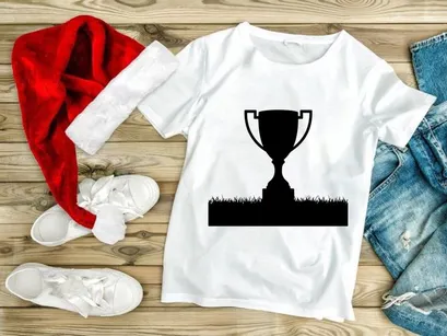A black silhouette of a trophy cup on a grassy field with white background