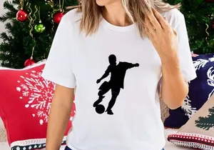 Silhouette of a soccer player kicking a ball in mid action