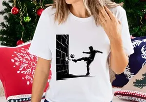 Soccer player kicking ball against brick wall in dynamic action pose