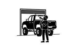 Silhouette of a man standing next to a large pickup truck in a garage