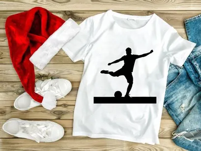 Silhouette of a soccer player kicking a ball in mid action with arms outstretched