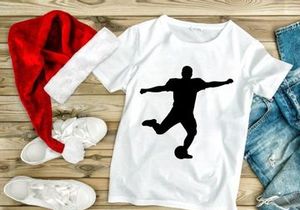 Silhouette of a soccer player kicking a ball in mid action