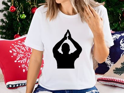 A person in a yoga pose with hands together above their head in silhouette