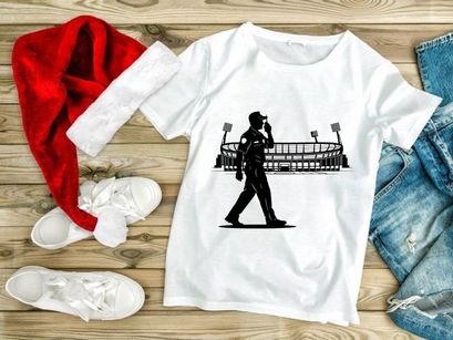 Silhouette of a man walking in front of a sports stadium at night