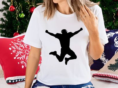 A person jumping in the air with arms outstretched in a celebratory pose silhouette