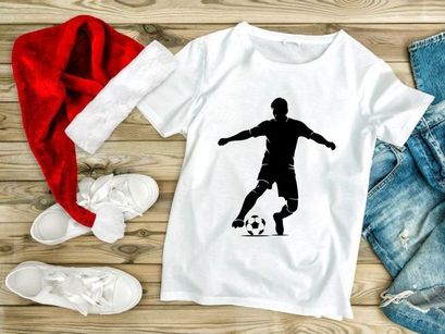 Silhouette of a soccer player kicking a ball in action