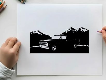 Silhouette of a pickup truck in front of mountains