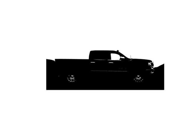 Silhouette of a pickup truck against a mountainous landscape