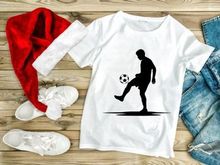 Silhouette of a soccer player kicking a ball in mid action