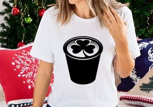 Black coffee cup with white shamrock foam design isolated