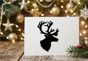Black silhouette of a reindeer head with large antlers isolated on a white background.