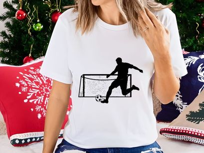 Soccer player kicking ball into goal net in action