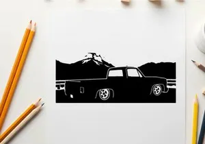 Silhouette of a pickup truck in front of mountains
