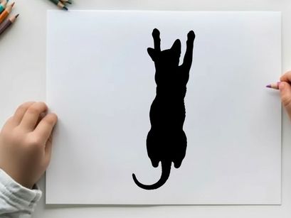 Silhouette of a cat jumping up with front paws raised high
