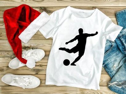 Silhouette of a soccer player kicking a ball in mid action