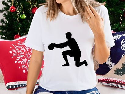 A silhouette of a man in a kneeling position holding a ball