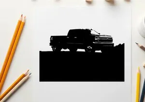 Silhouette of a pickup truck against a mountain range
