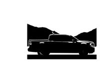 Silhouette of a pickup truck against a mountain range silhouette