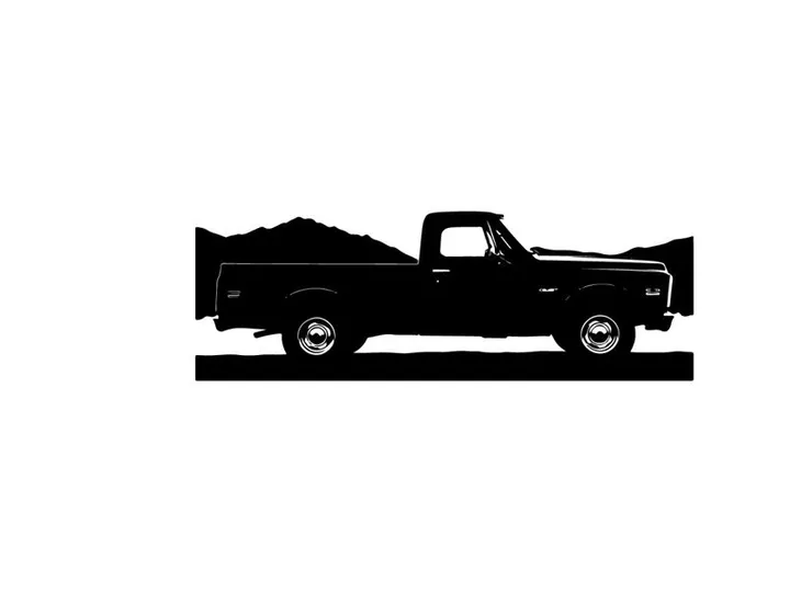 Silhouette of a pickup truck against a mountain range silhouette
