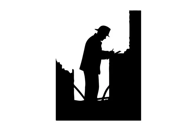 Silhouette of a man working on a construction site at night