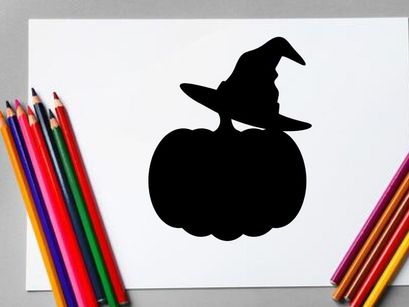 Silhouette of a witch with a broomstick on a pumpkin at night