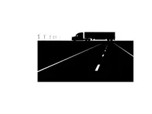 Silhouette of a semi truck driving down a highway at night