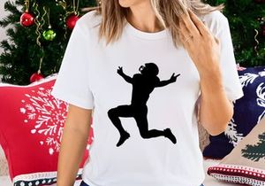 Silhouette of a person jumping in the air with arms outstretched and wearing a helmet