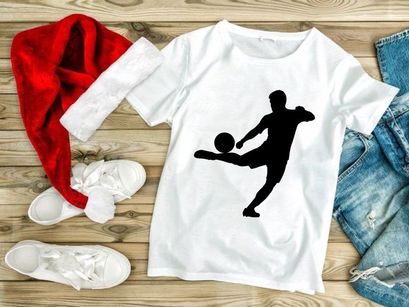 Silhouette of a soccer player kicking a ball in mid action