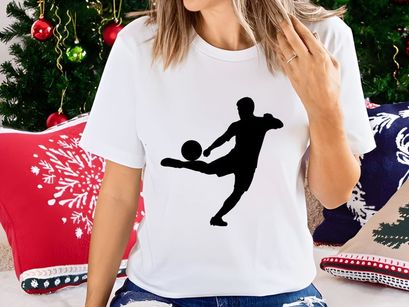 Silhouette of a soccer player kicking a ball in mid action