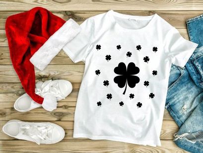 Black four leaf clover with scattered shamrocks on white background