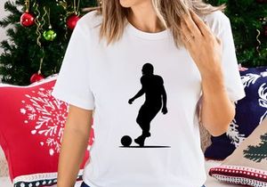 Silhouette of a soccer player kicking a ball in motion