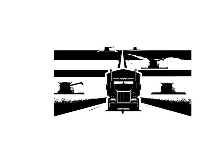 Truck driving down a highway in silhouette at dusk