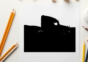 Silhouette of a semi truck driving on a road with mountains