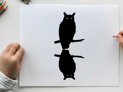 Silhouette of an owl perched on a branch with reflection