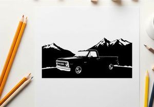 Silhouette of a pickup truck in front of mountains