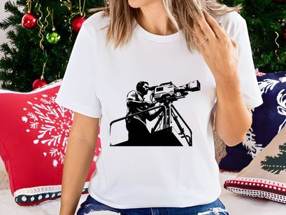 A cameraman operating a large video camera on a tripod stand