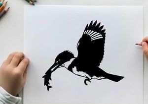Silhouette of a kingfisher in flight with fish