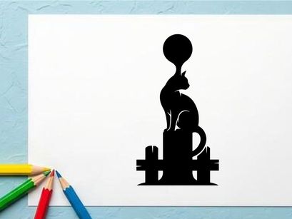 Silhouette of a cat with a balloon on its head sitting on a fence at sunset