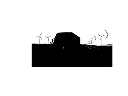 Silhouette of a truck driving past wind turbines on a highway