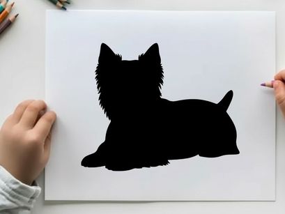 Silhouette of a small black dog lying down calmly
