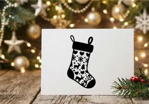 Black and white Christmas stocking icon with reindeer and snowflake pattern design.