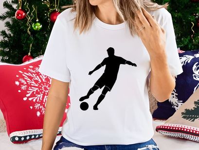 Silhouette of a soccer player kicking a ball in motion