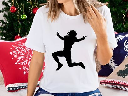 Silhouette of a person jumping in the air with arms outstretched and wearing a helmet