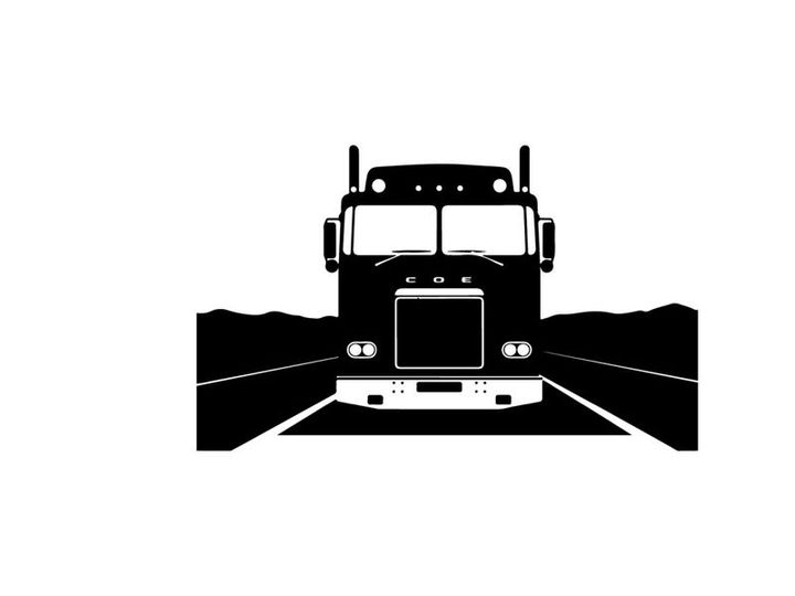A silhouette of a semi truck driving down a highway at night