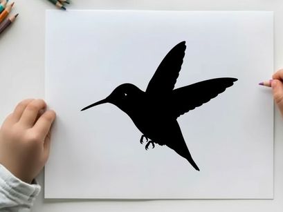 Silhouette of a hummingbird in flight against a white background