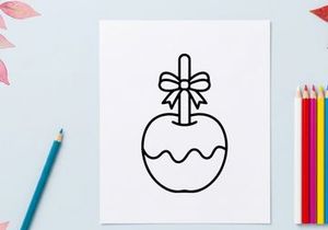 Hand-drawn apple with bow illustration for holiday gift tags. Simple black and white fruit sketch for seasonal branding and packaging design.