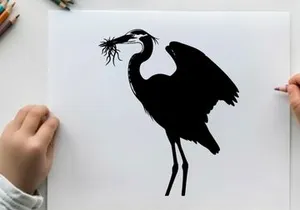 Silhouette of a heron building a nest with twigs and branches