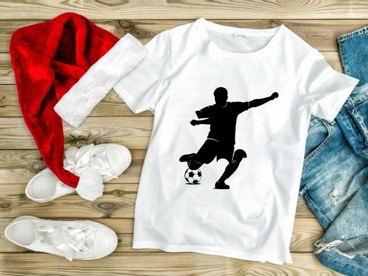 Silhouette of a soccer player kicking a ball in mid action