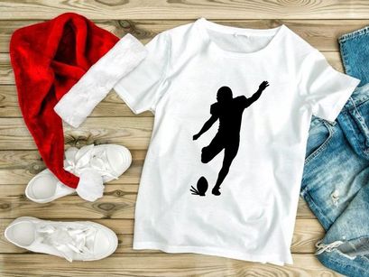 Silhouette of a soccer player kicking a ball in mid action