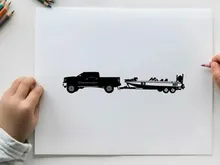 Silhouette of a pickup truck towing a boat trailer